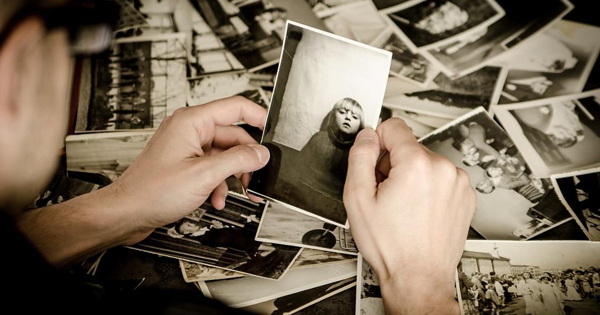 Ruce prohlížející staré černobílé fotografie